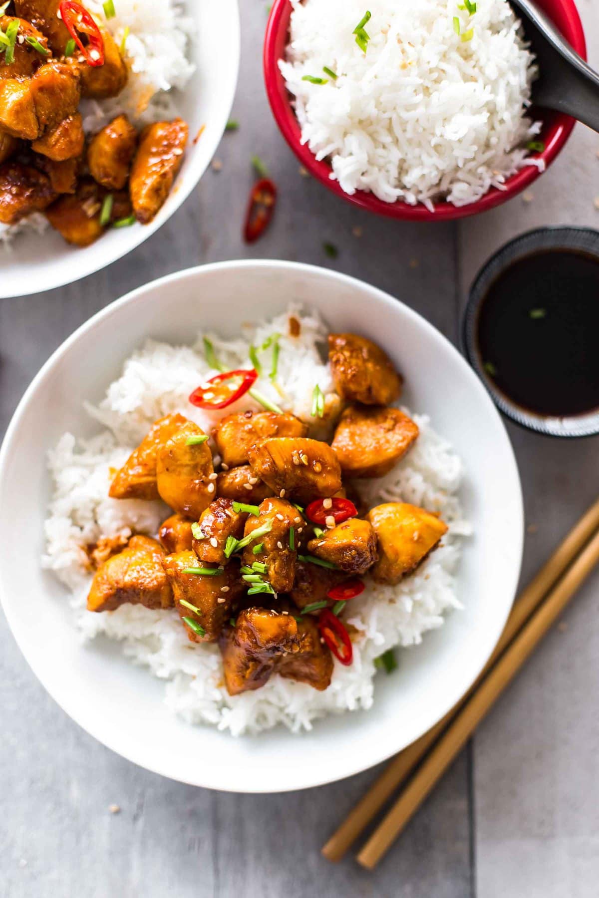 bowls of white rice and bourbon chicken on a table