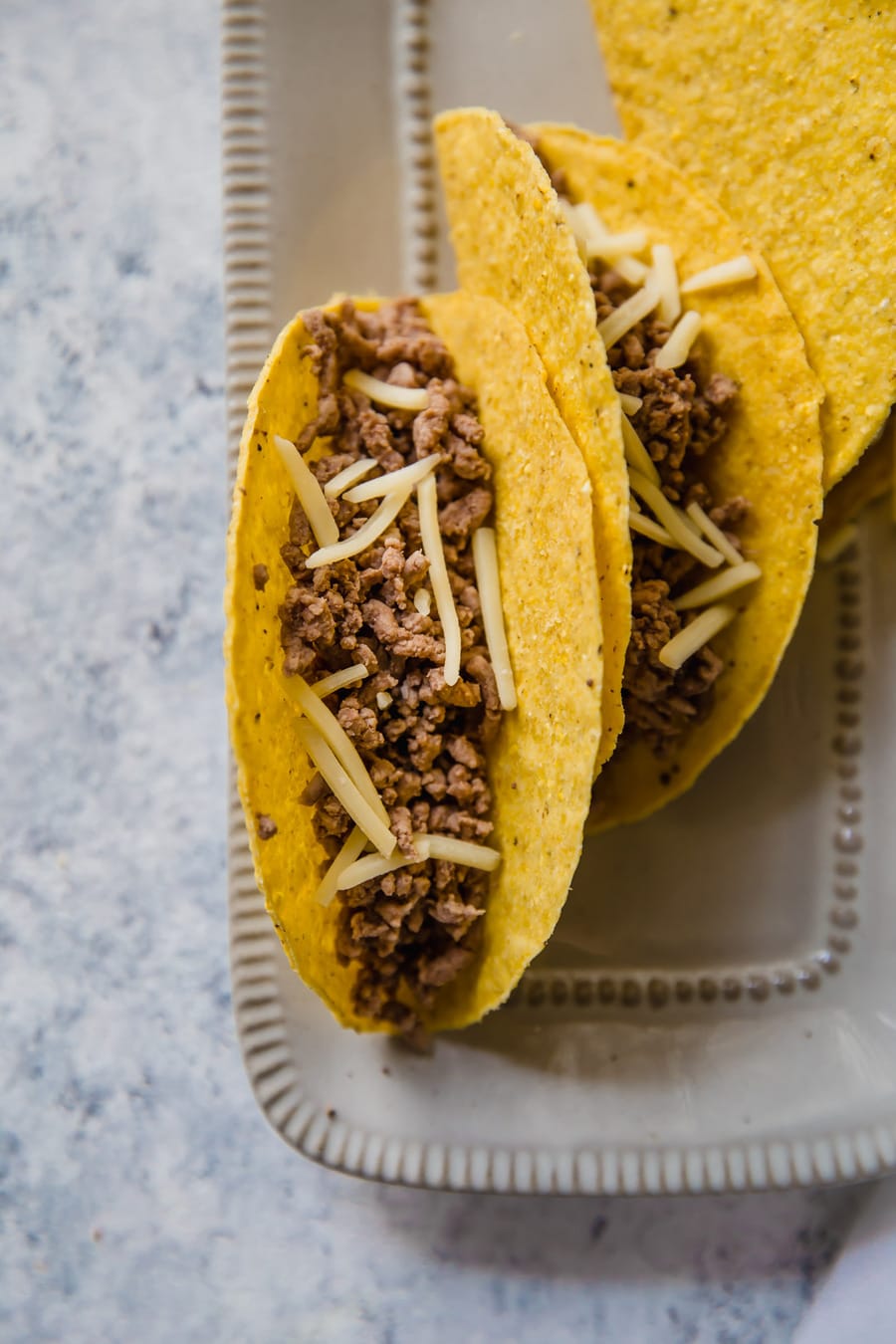 tacos filled with cooked ground beef.