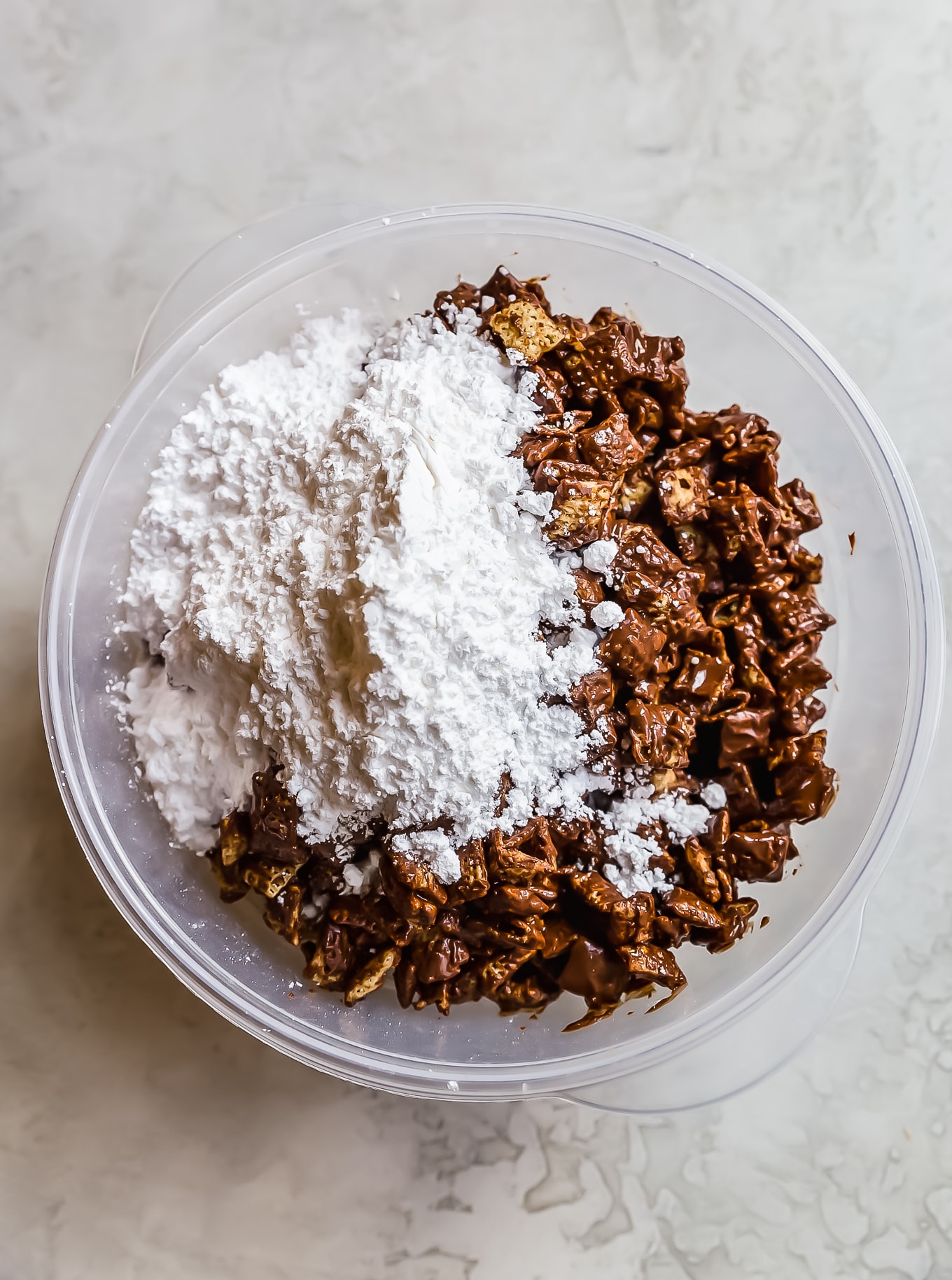 crispix cereal, chocolate, and powdered sugar in a mixing bowl