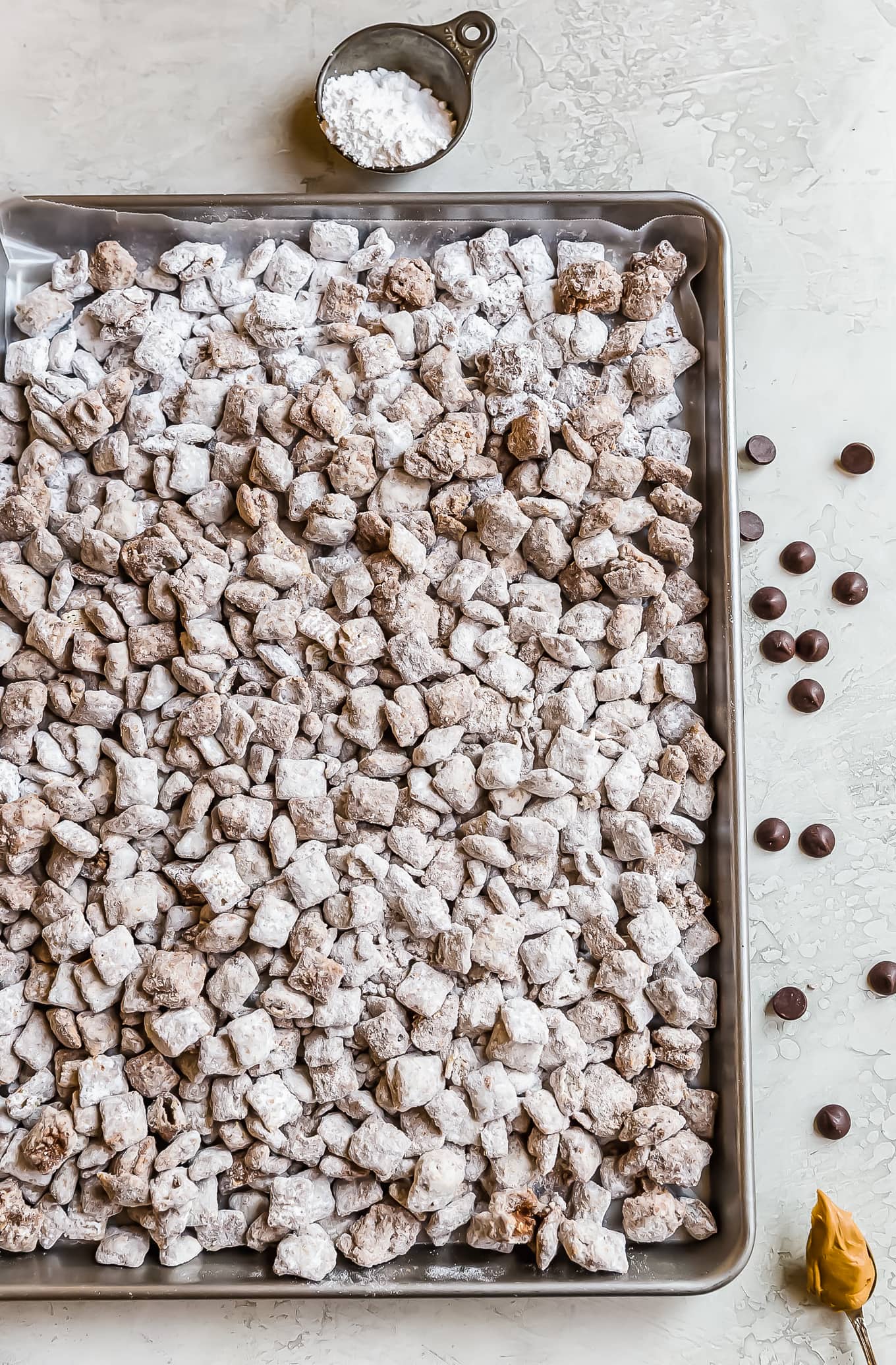 puppy chow spread out on a baking tray