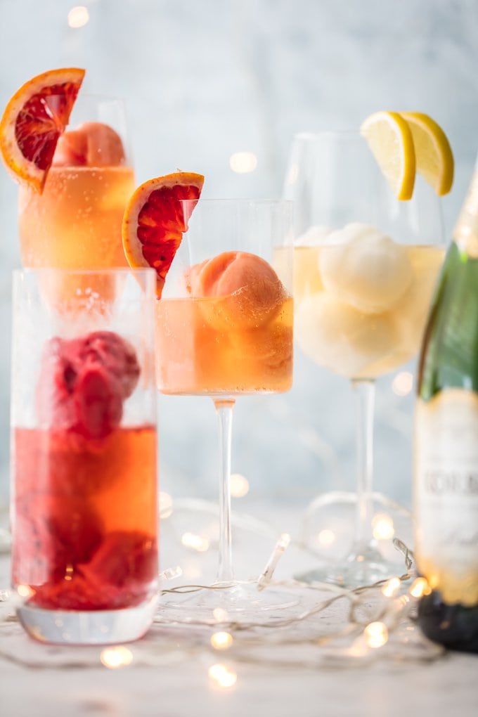 Glass of sherbet filled with champagne and garnished with slice citrus