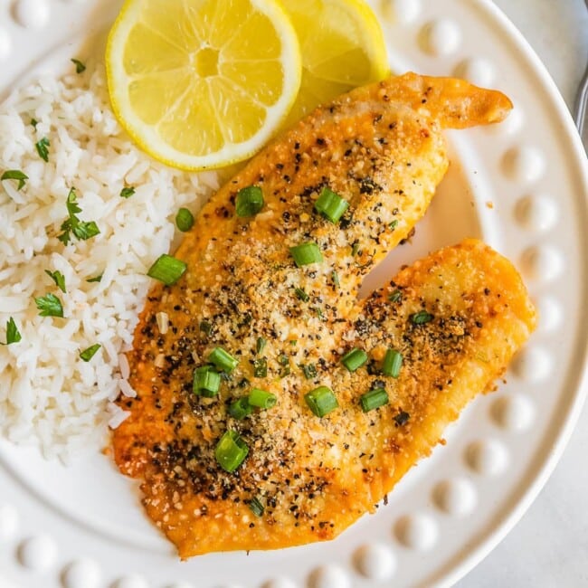 Parmesan Crusted Lemon Pepper Tilapia is the BEST Tilapia Recipe we have ever tasted. This Parmesan Crusted Tilapia is as healthy as it is delicious, and it's SUPER EASY as well! This Lemon Pepper Tilapia Recipe is so flavorful and made in under 20 minutes. Best Easy Seafood Recipe.