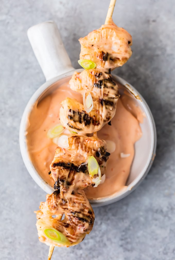 a skewer of bang bang shrimp on a dish of bang bang sauce