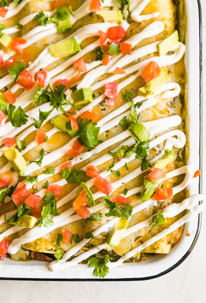 tomatoes, avocados, and sour cream on enchiladas