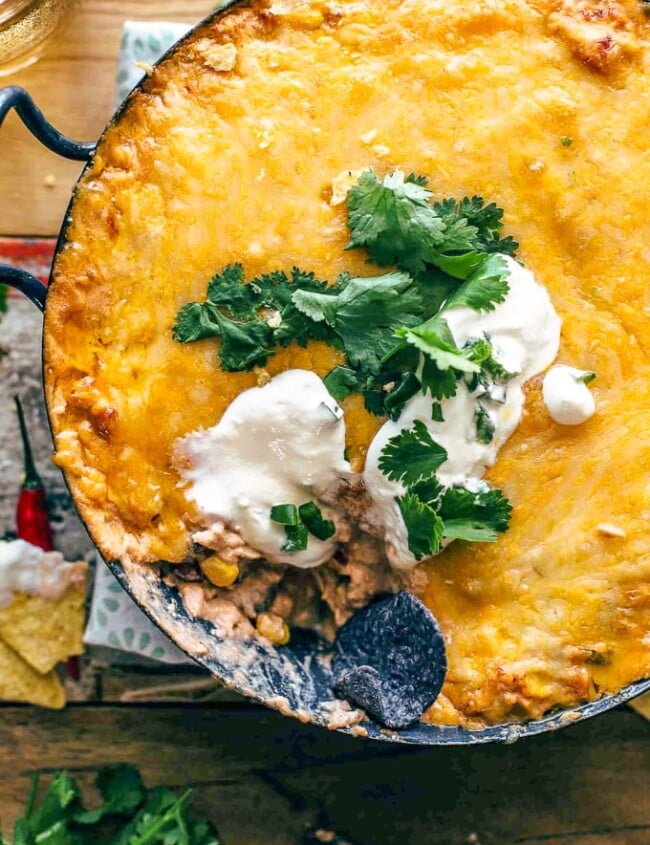 Chicken Enchilada Dip is one of the cheesiest and most delicious dips I've ever made. This easy Tex Mex dip recipe is filled with chicken, cream cheese, corn, beans, tomatoes, and enchilada sauce. It's sure to be an instant favorite on game day, or at any get-together!