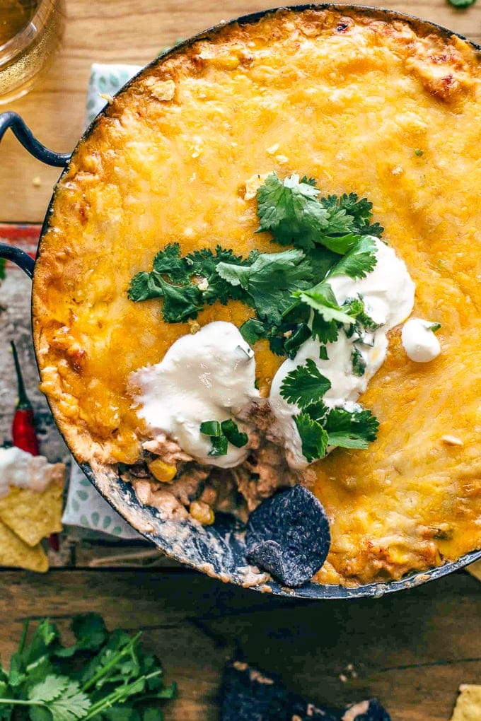 Chicken Enchilada Dip topped with cheese, sour cream, and cilantro