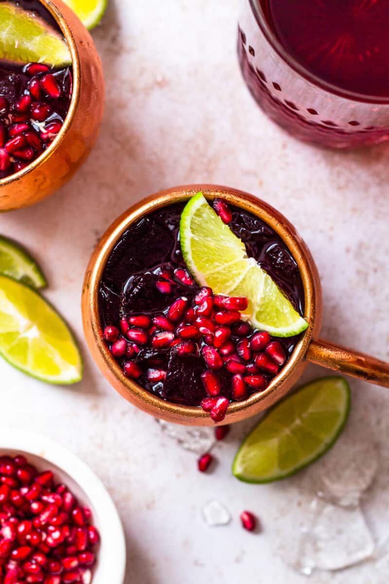 overhead pomegranate moscow mules garnished with limes and pomegranate seeds