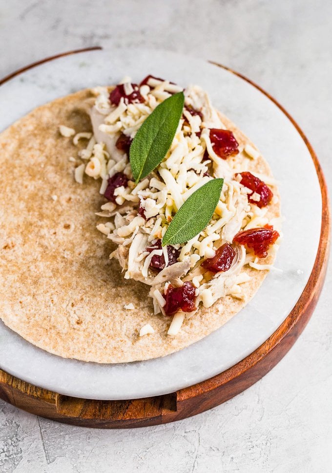 Turkey, Cheese, Cranberry, and Sage laid out on a tortilla to make a Thanksgiving Leftover Quesadilla.