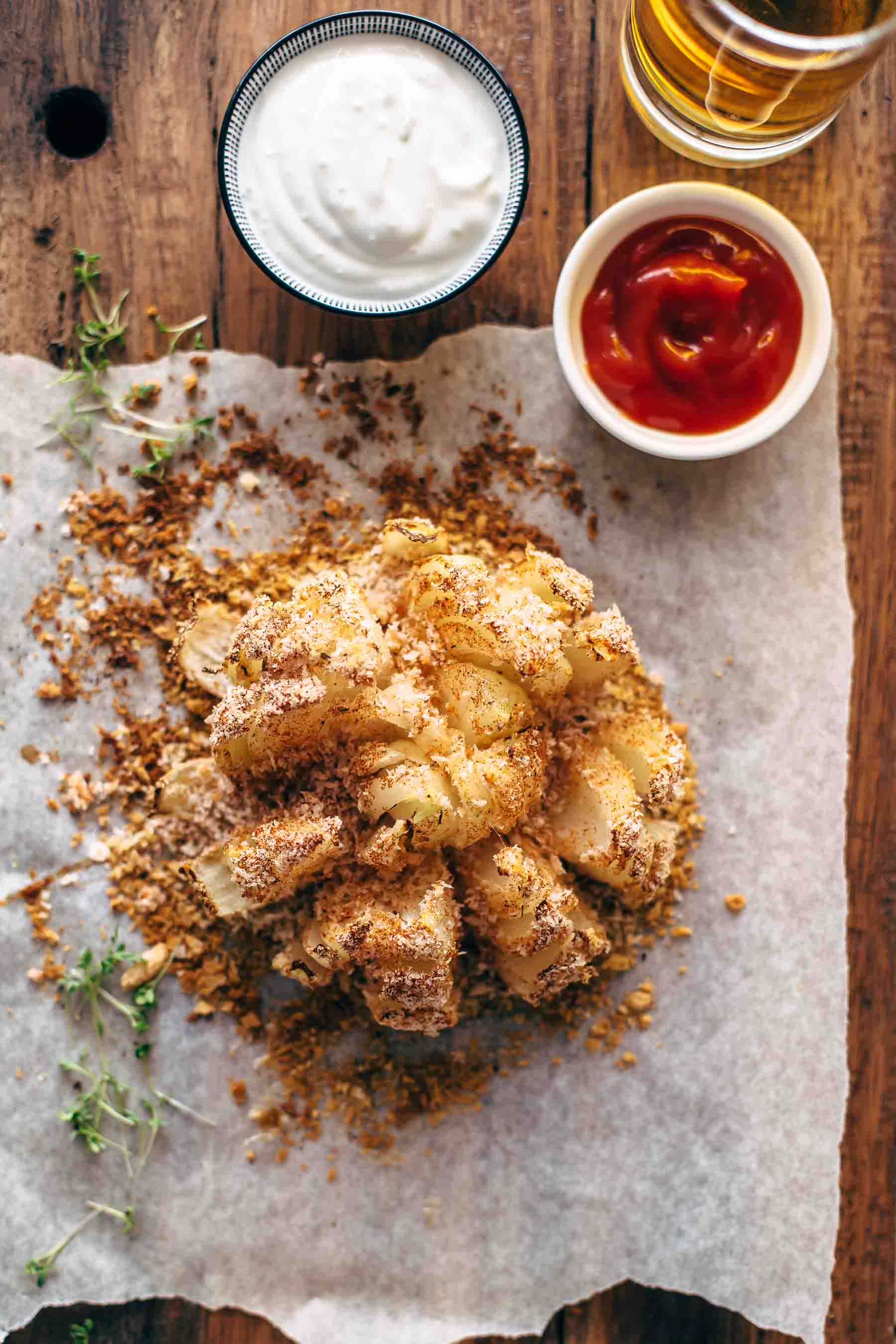 overhead shot of baked blooming onion with dipping sauces