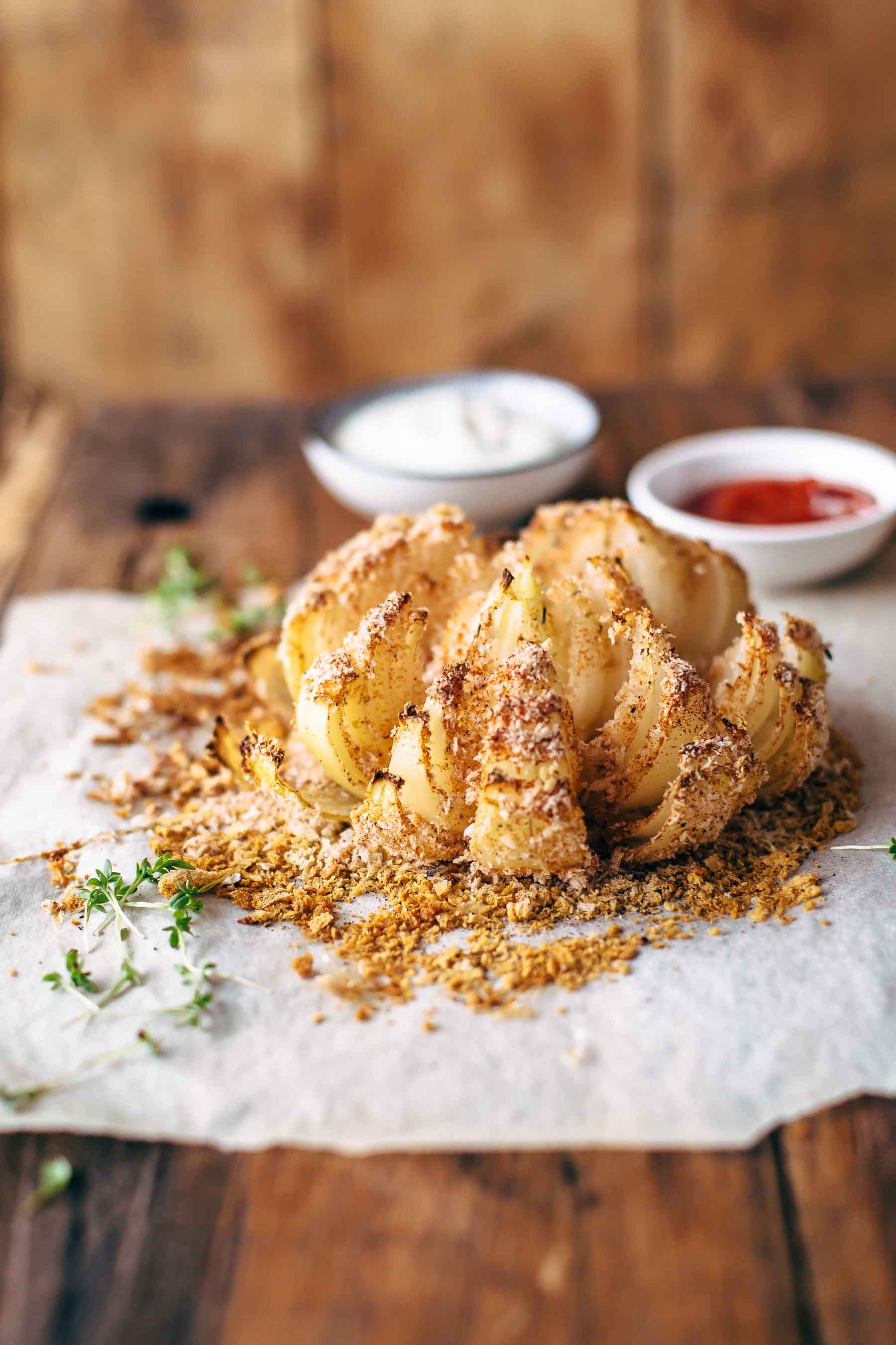 side shot of baked blooming onion recipe with dipping sauces