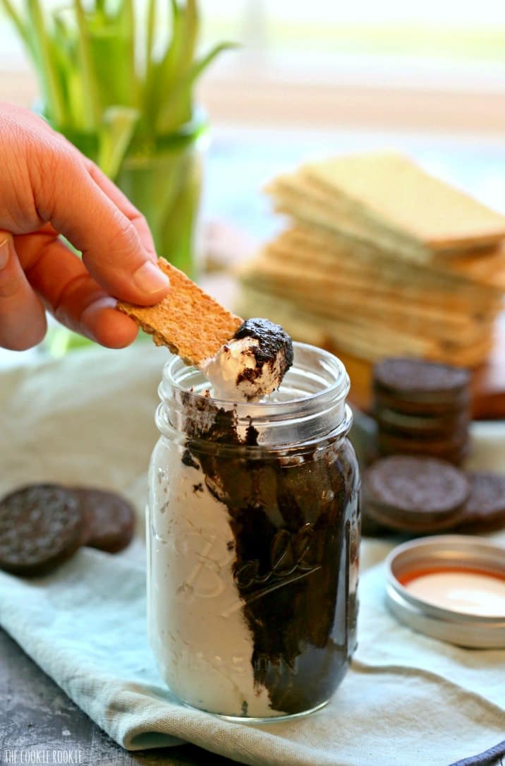 hand scooping out butter with graham cracker