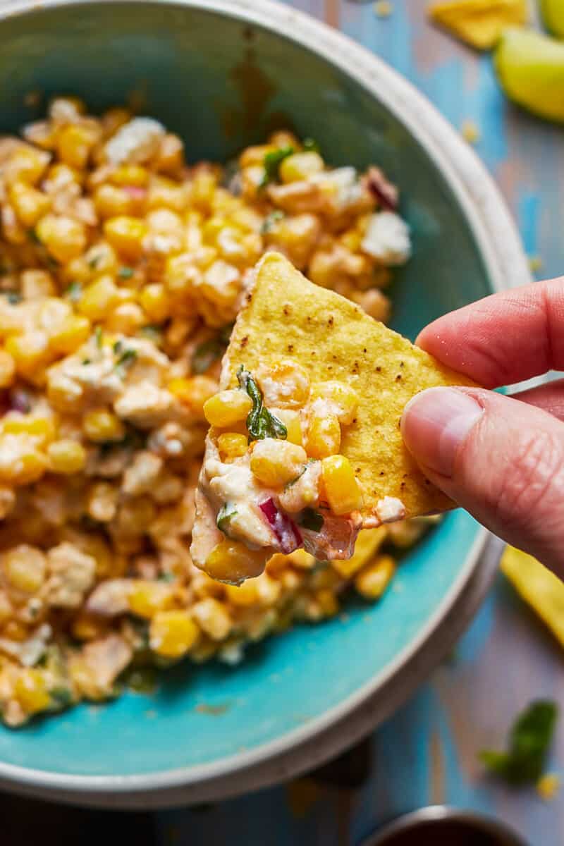 close up on tortilla chip with creamy street corn