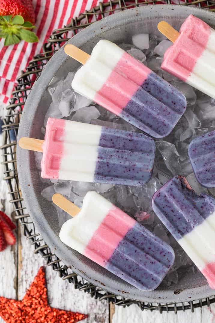 Red White and Blue Smoothie Popsicles laying flat down on a bed of ice