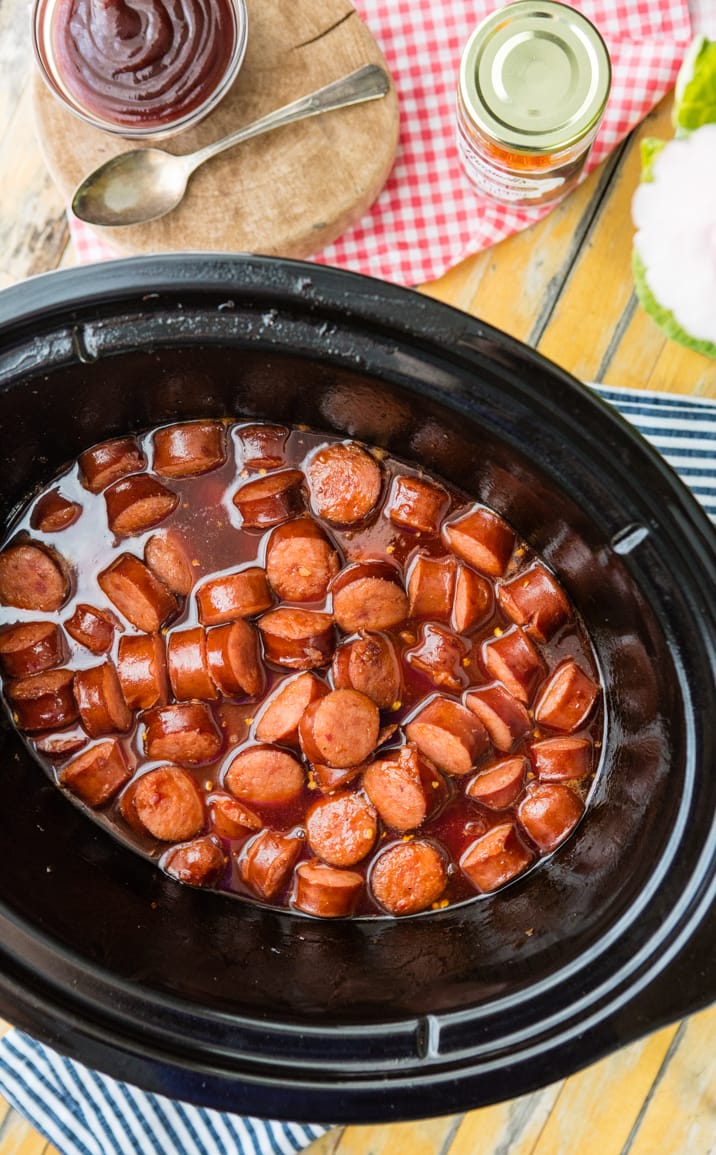 Slow Cooker Sweet and Spicy Kielbasa is our FAVORITE easy party appetizer! Made with pepper jelly and bbq sauce, SO GOOD!