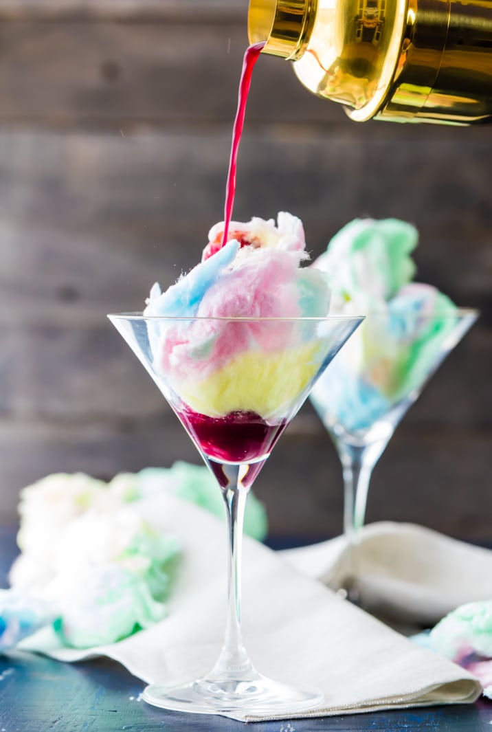 cocktail being poured into martini glass full of cotton candy