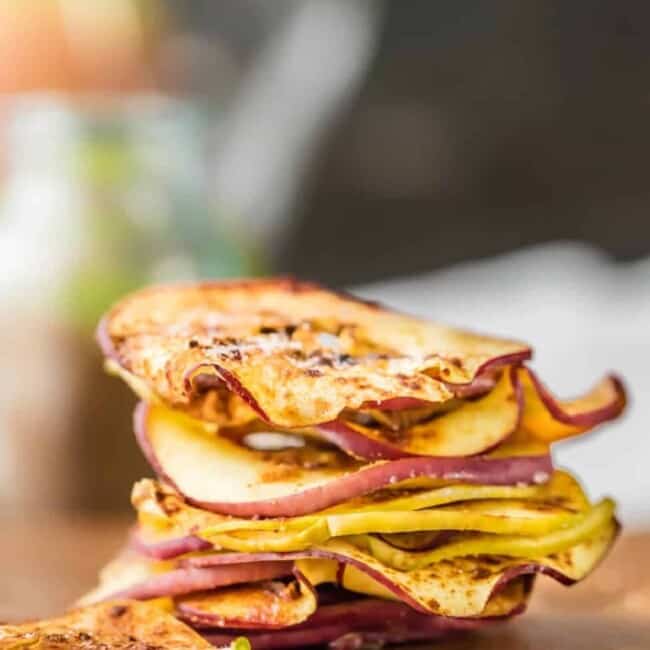 A stack of apple slices on a cutting board for making microwave apple chips.