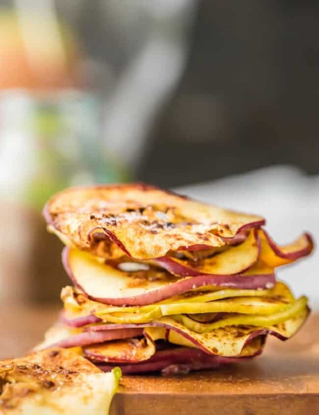 A stack of apple slices on a cutting board for making microwave apple chips.