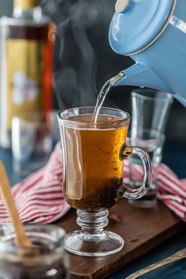 Pouring hot water from a kettle into a glass mug