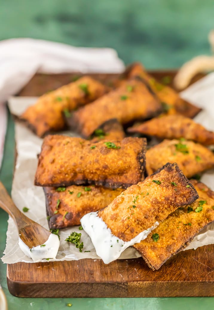 mini fried taco pizza pockets with sour cream on a spoon