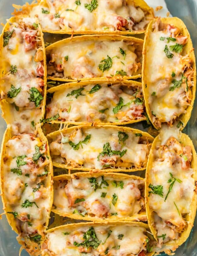 SUPER EASY Oven Baked Spicy Chicken Tacos make a weekly appearance on our table. All the flavor and none of the stress. ALL THAT MELTED CHEESE! Perfect Chicken Tacos recipe for a crowd on Family Mexican Night!