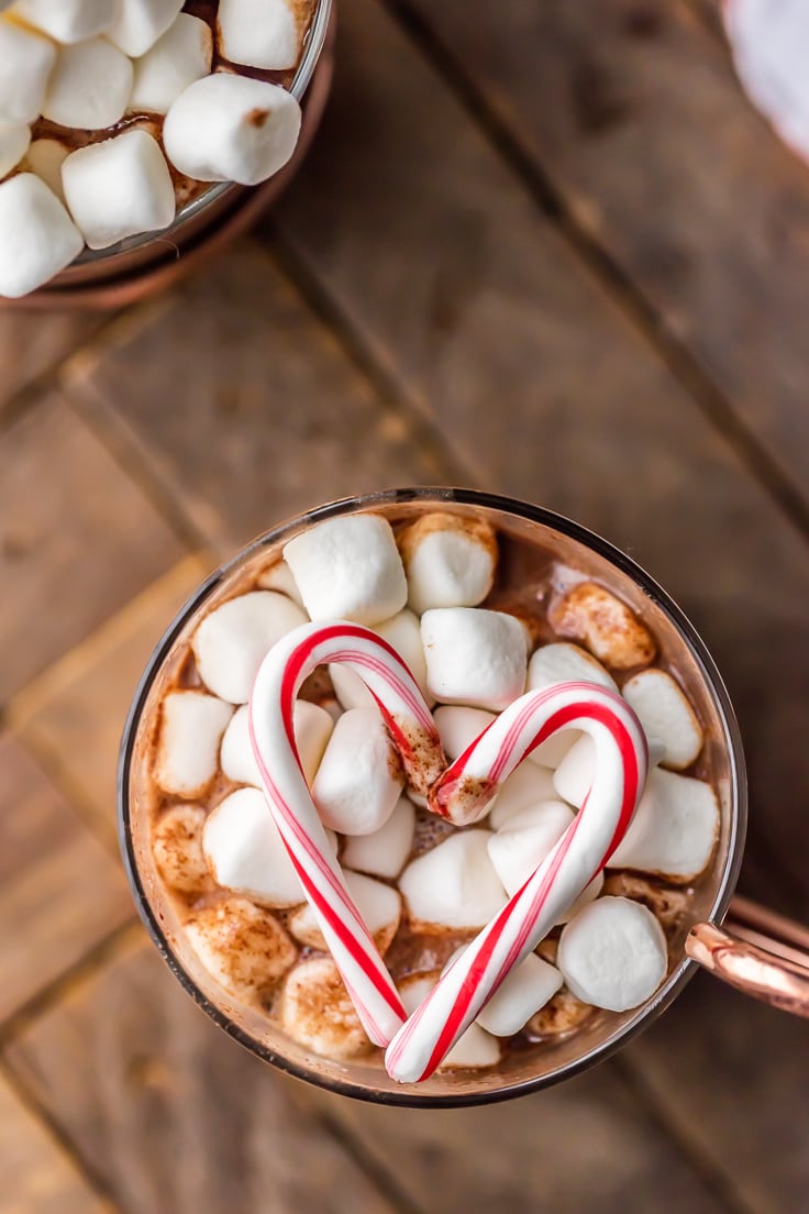 Overhead view of peppermint hot chocolate topped with marshmallows and candy canes in the shape of a heart