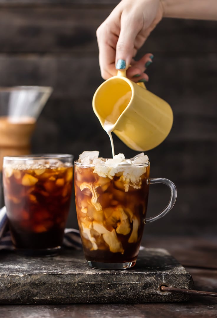 creamer being poured in iced coffee mug