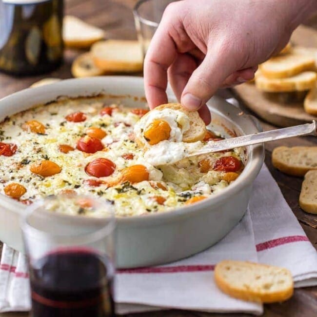 Goat Cheese Dip filled with cherry tomatoes, basil, garlic, and more is my FAVORITE EASY CHEESE DIP APPETIZER! It's classy, it's simple to make, and it's so delicious. Serve this baked cheese dip hot with some crostini, toasted bread, or hearty crackers.