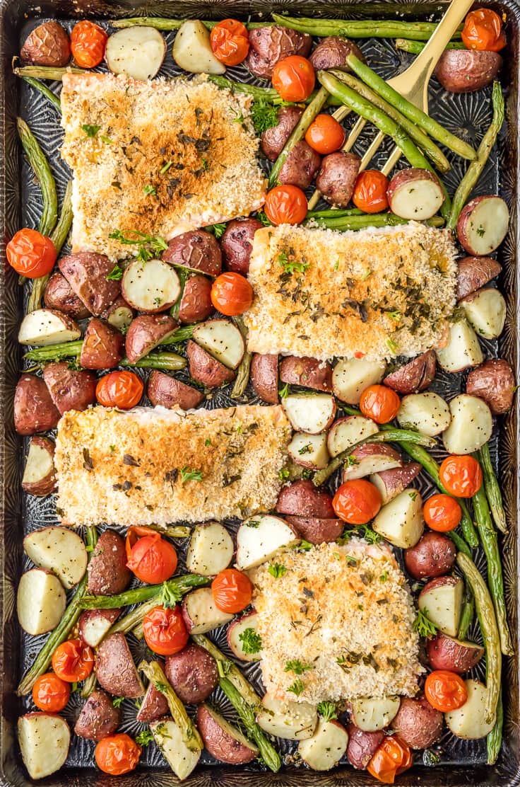 sheet pan filled with honey mustard salmon and potatoes, green beans, and tomatoes