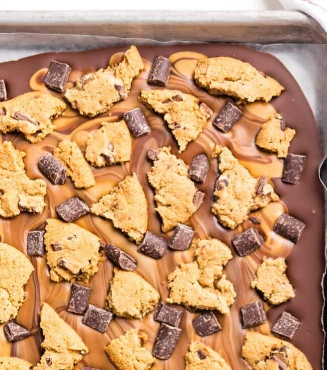 Peanut Butter Chocolate Chip Cookie Bark is the ULTIMATE easy dessert recipe! Only 4 ingredients stand between you and this party favorite. Loaded with peanut butter, milk chocolate, dark chocolate chunks, and chocolate chip cookies! Great last minute sweet treat for tailgating.