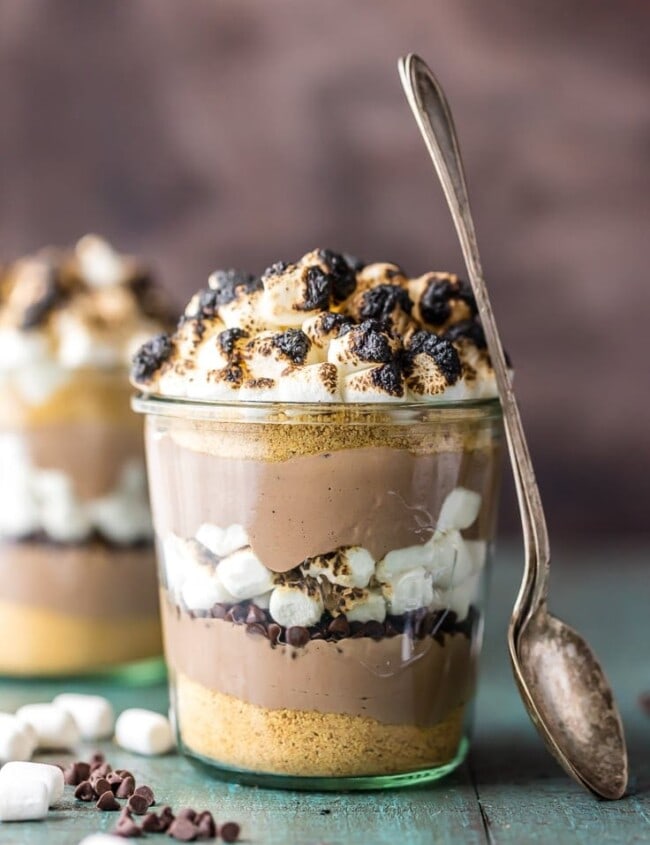 This S'mores Breakfast Parfait recipe is sure to make your mornings great! This delicious s'mores inspired recipe is loaded with Greek yogurt, protein powder, graham cracker crumbs, chocolate chips, and toasted marshmallows. A delicious and easy yogurt parfait to start your day!