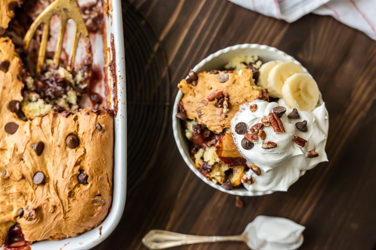 dump cake in a bowl, topped with whipped cream and bananas