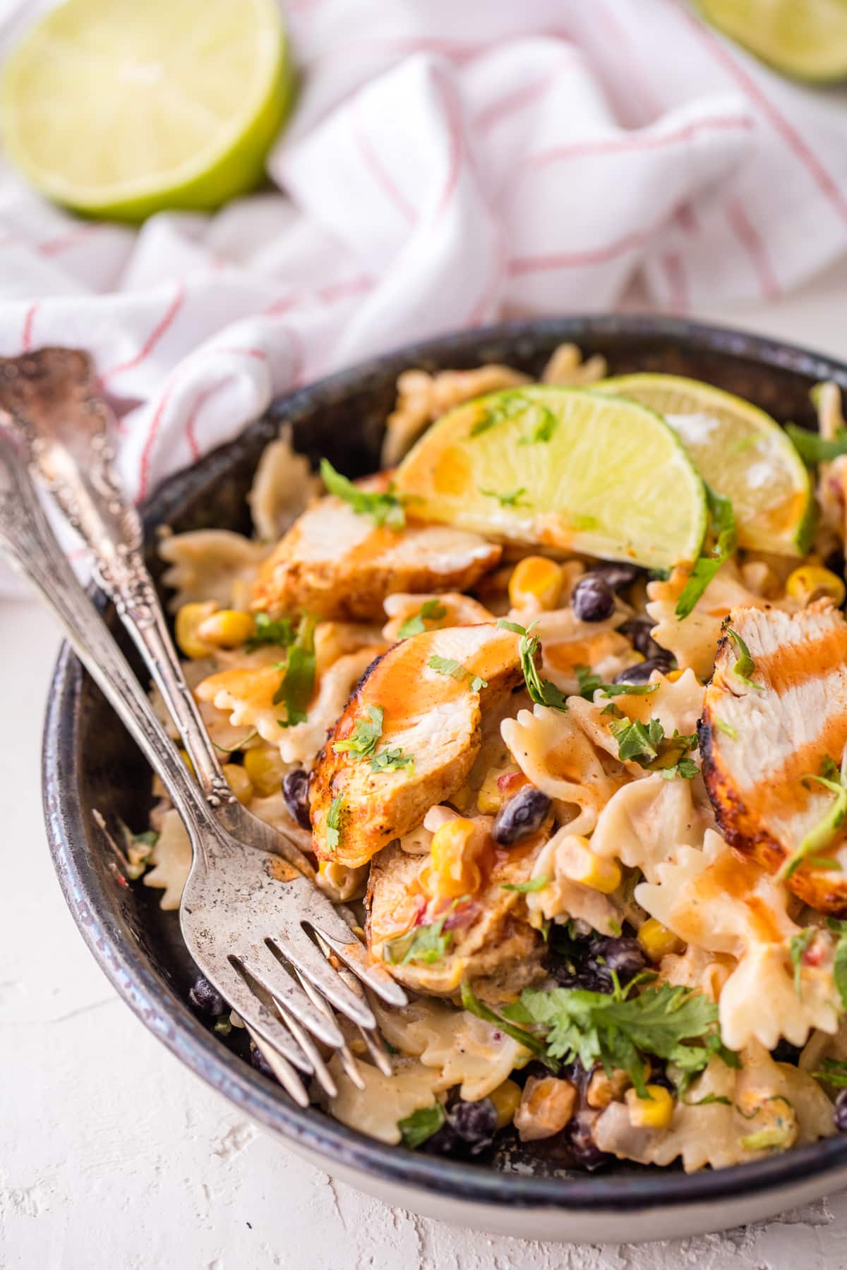 bowl of pasta salad topped with chicken and enchilada sauce