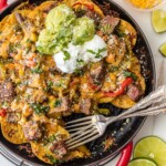 steak fajita nachos in a baking dish with two forks