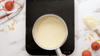 A person making buffalo chicken enchiladas on a stove top.