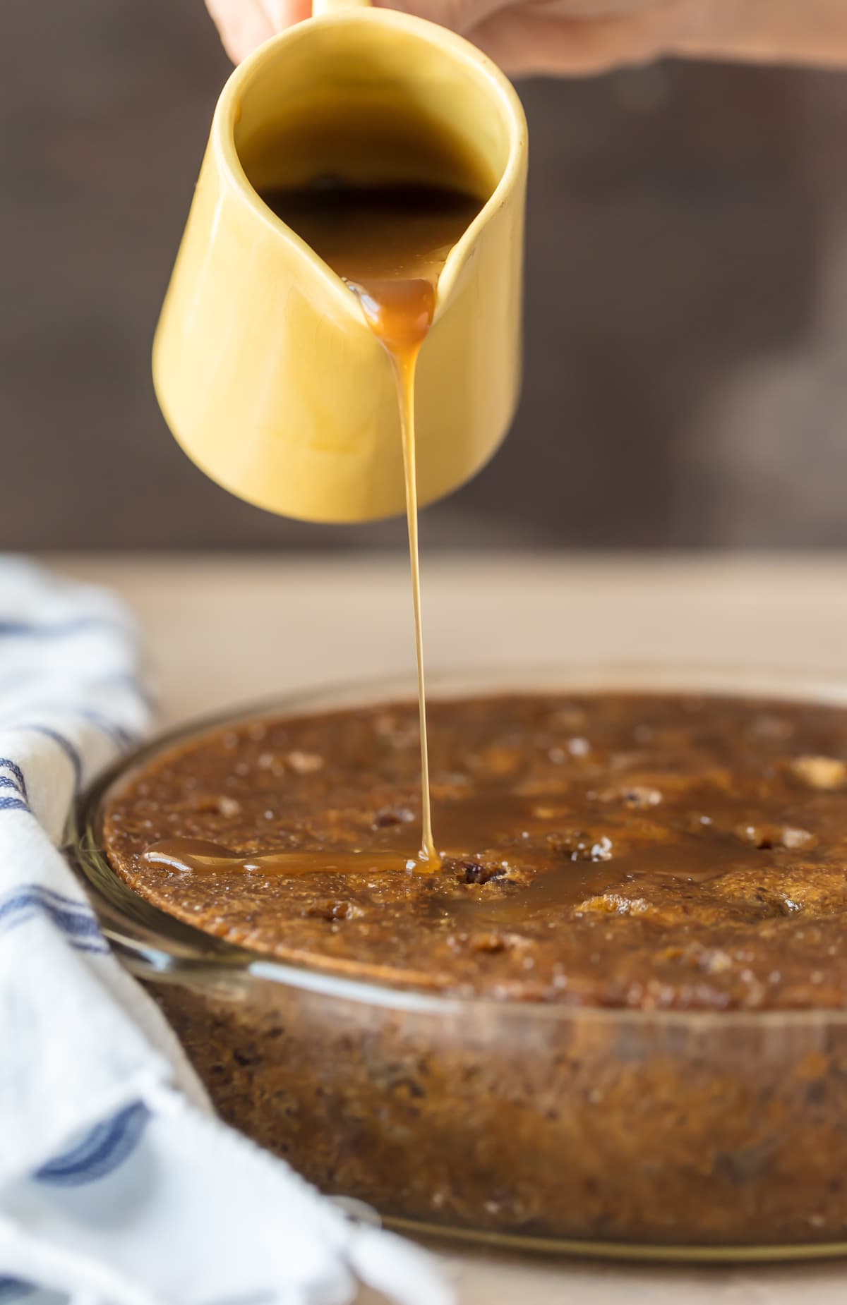 Pouring toffee sauce over a Sticky Toffee Pudding Poke Cake