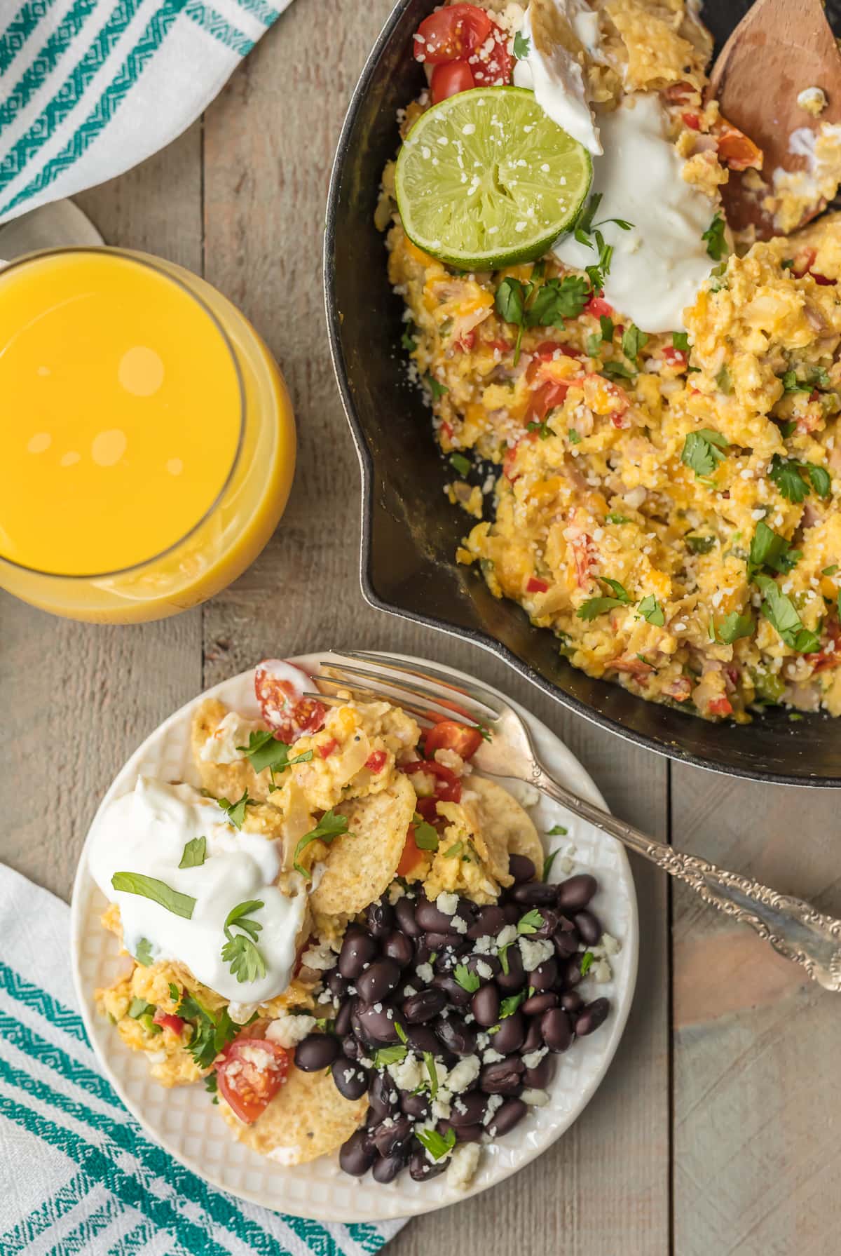 Skillet of eggs next to a plate of migas and black beans