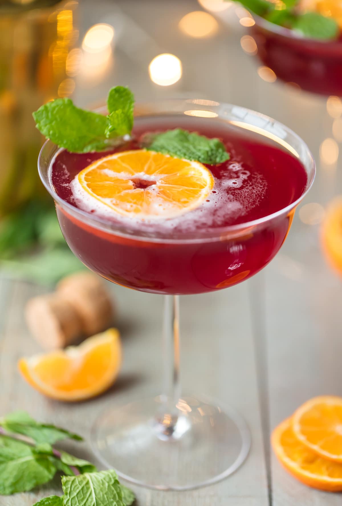 Holiday Flirtini Recipe garnished with orange and mint