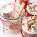 malted instant hot chocoalte mix in a bowl next to hot chocolate in mugs