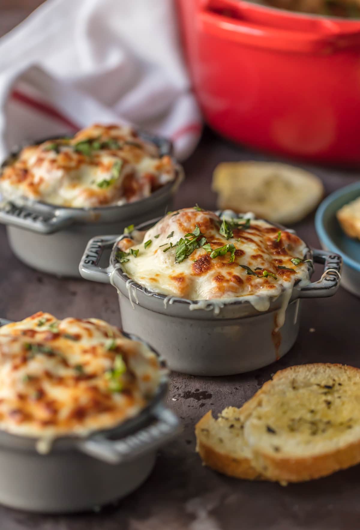 Meatball Soup in bowls, topped with a layer of melted cheese