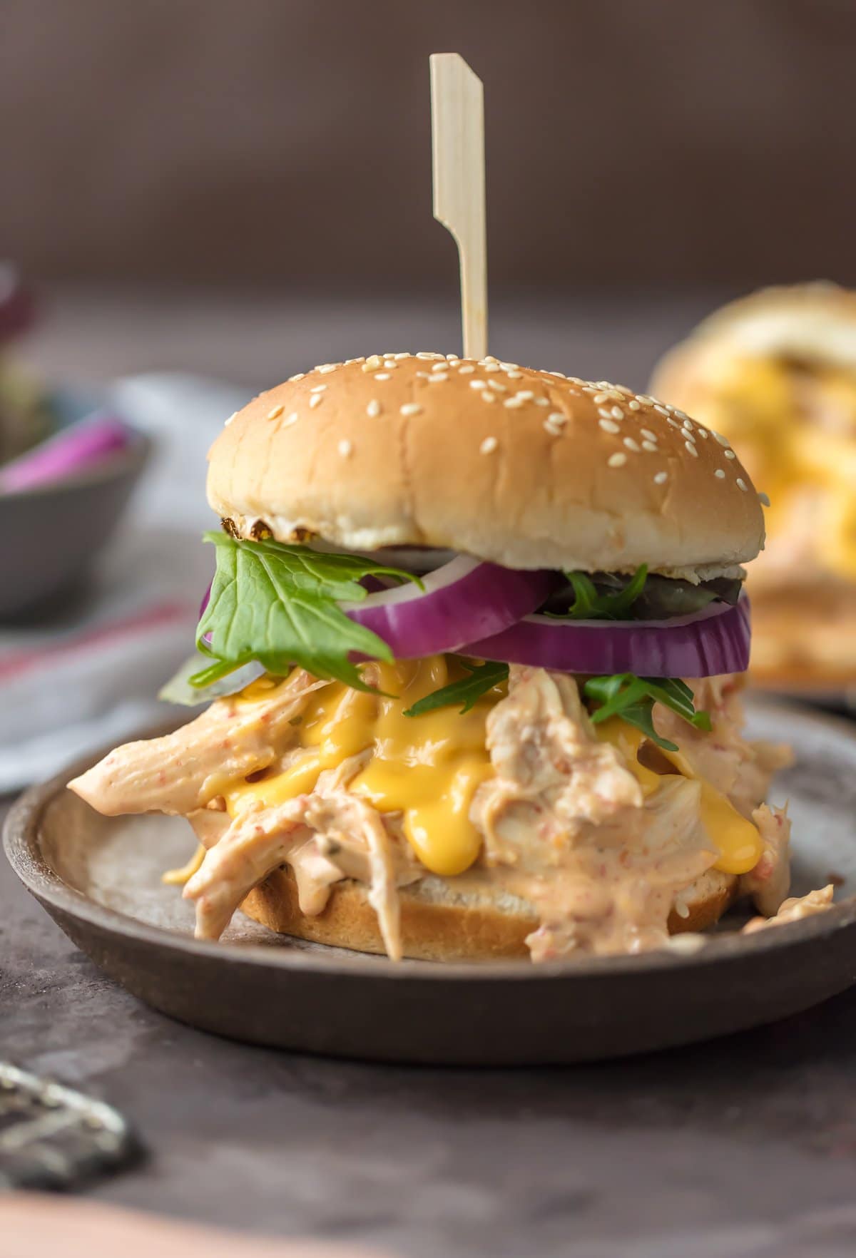 Slow Cooker Rotel Dip Chicken Sandwich, on a hamburger bun with lettuce and onion