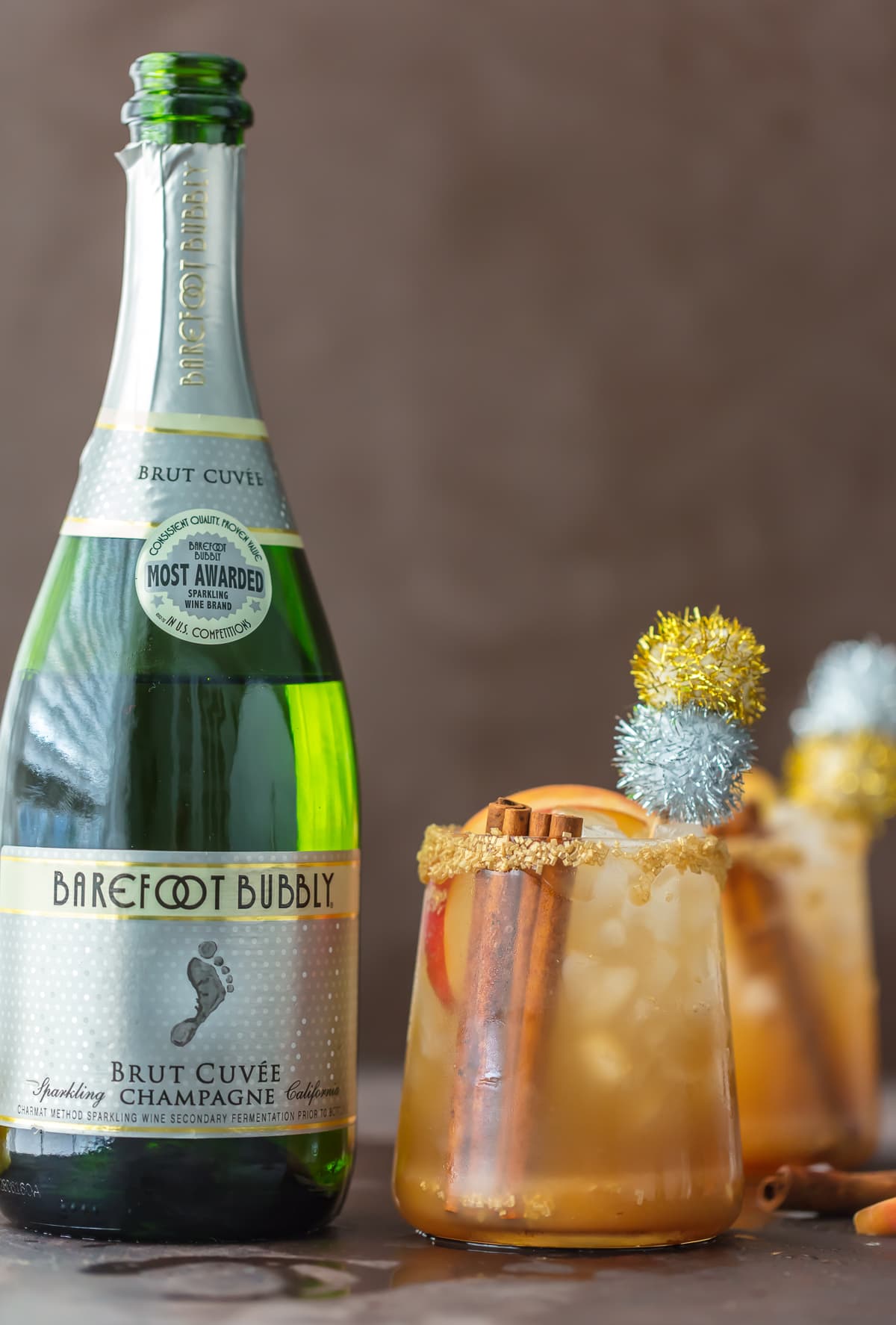 Caramel Apple Cider Cocktail in a glass, next to a bottle of champagne