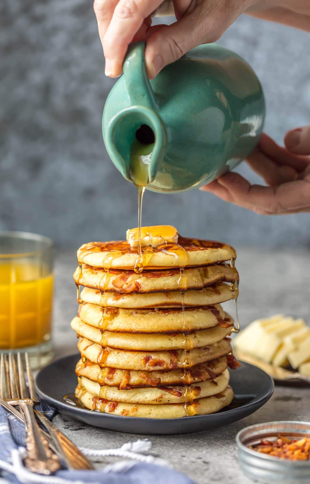 A stack of bacon pancakes with syrup