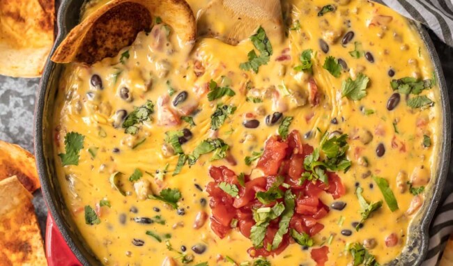 LOADED COWBOY QUESO is the ultimate Super Bowl dip! This EASY appetizer is loaded with velveeta, pepper jack, black beans, Rotel, and sausage! OUR FAVORITE TAILGATING DIP RECIPE!