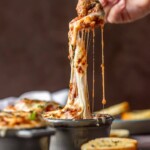 fork putting up cheesy meatball soup from bowl