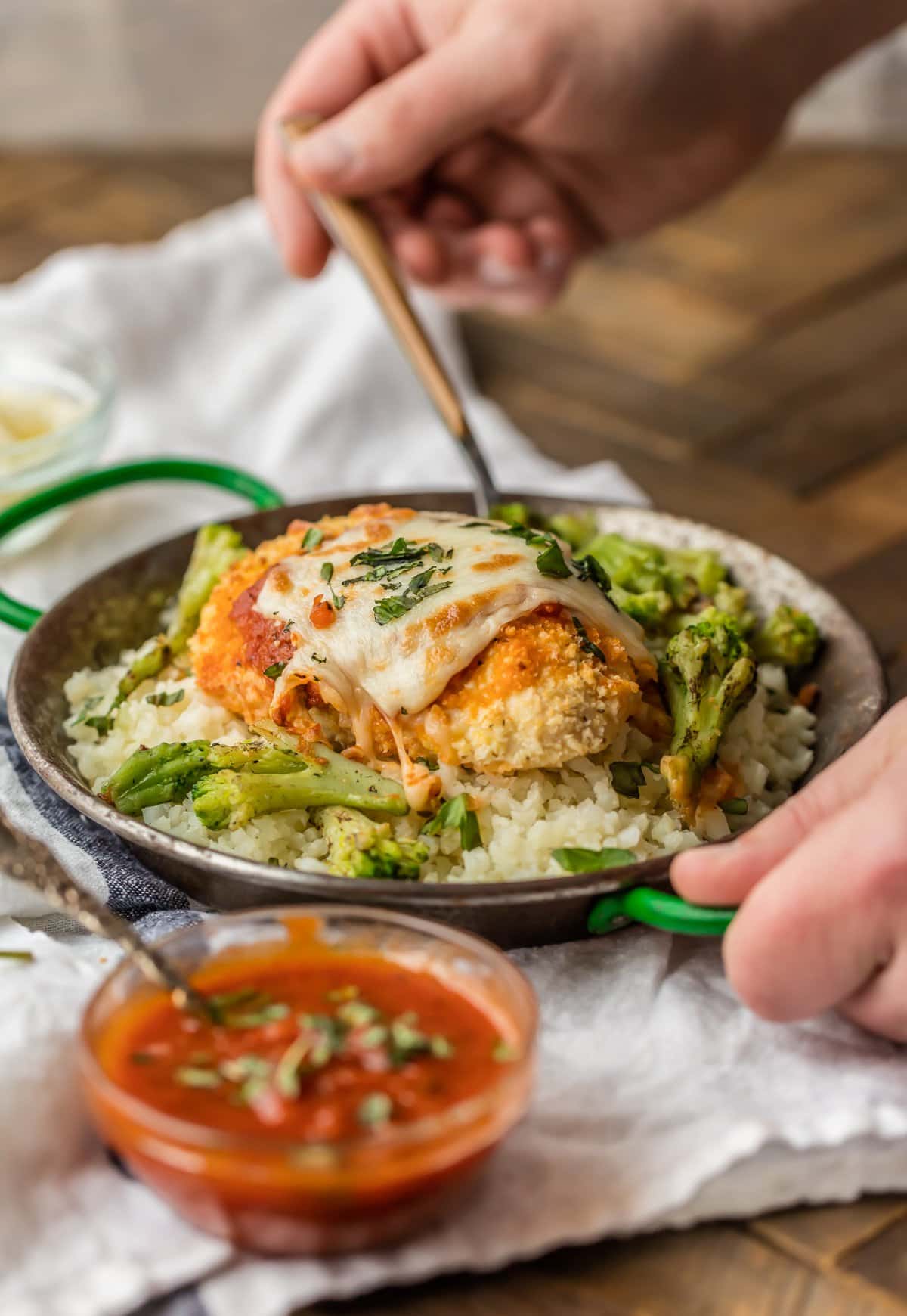 A bowl filled with cauliflower rice and baked chicken parmesan