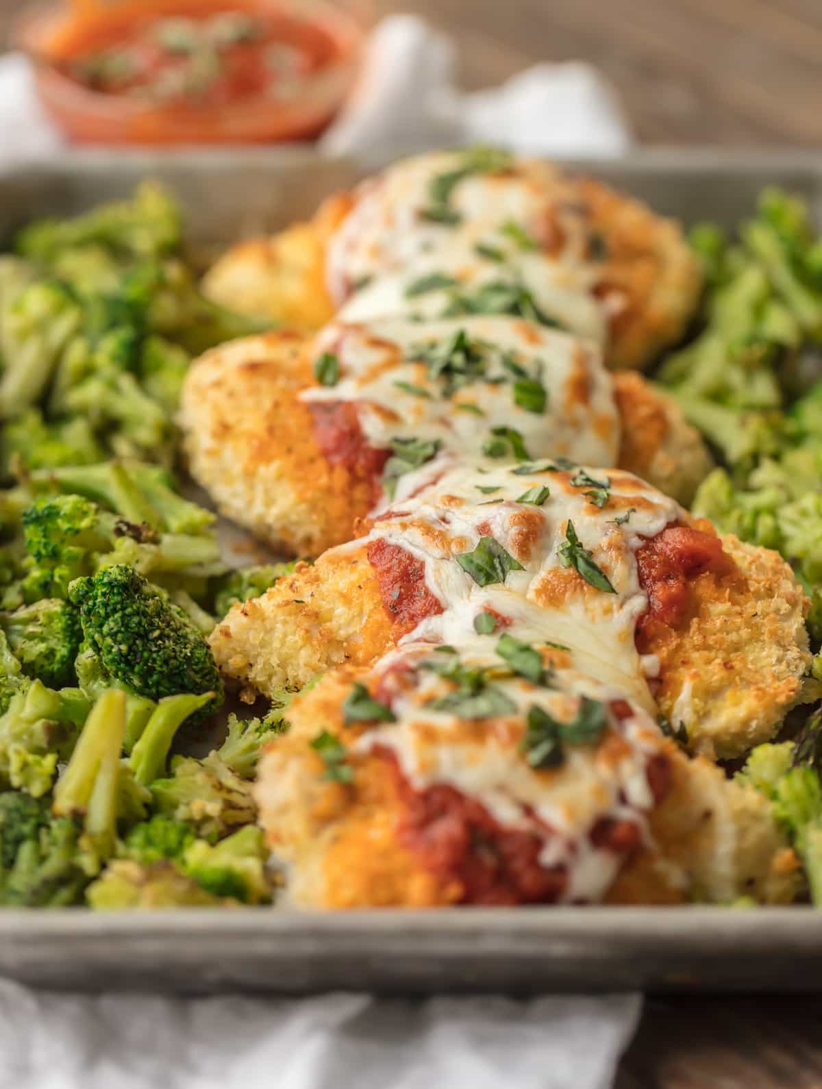 Sheet pan chicken parmesan topped with mozzarella and marinara