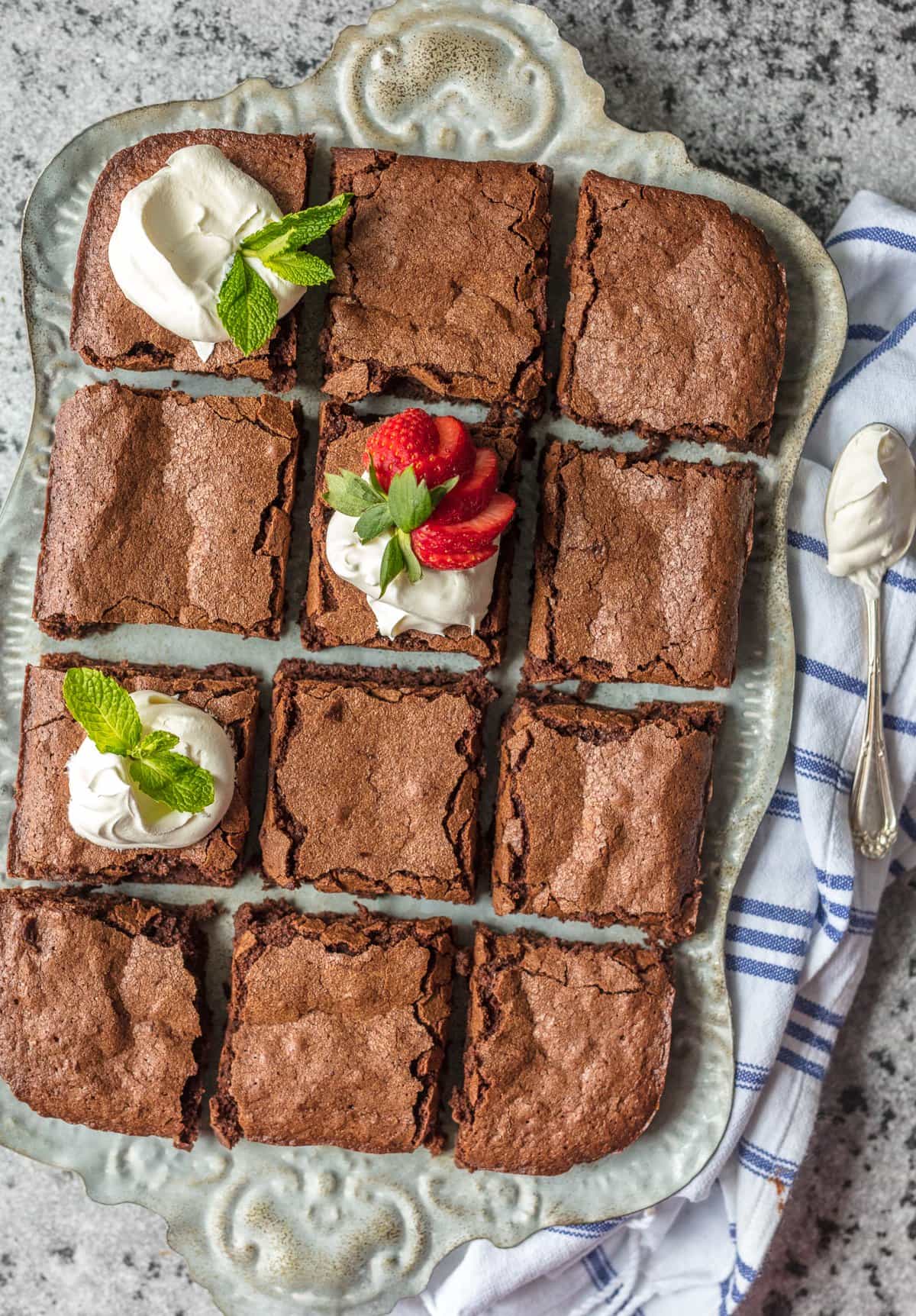 overhead view of a homemade brownie sliced into pieces on a tray.