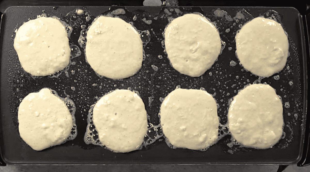 8 pancakes on a griddle.