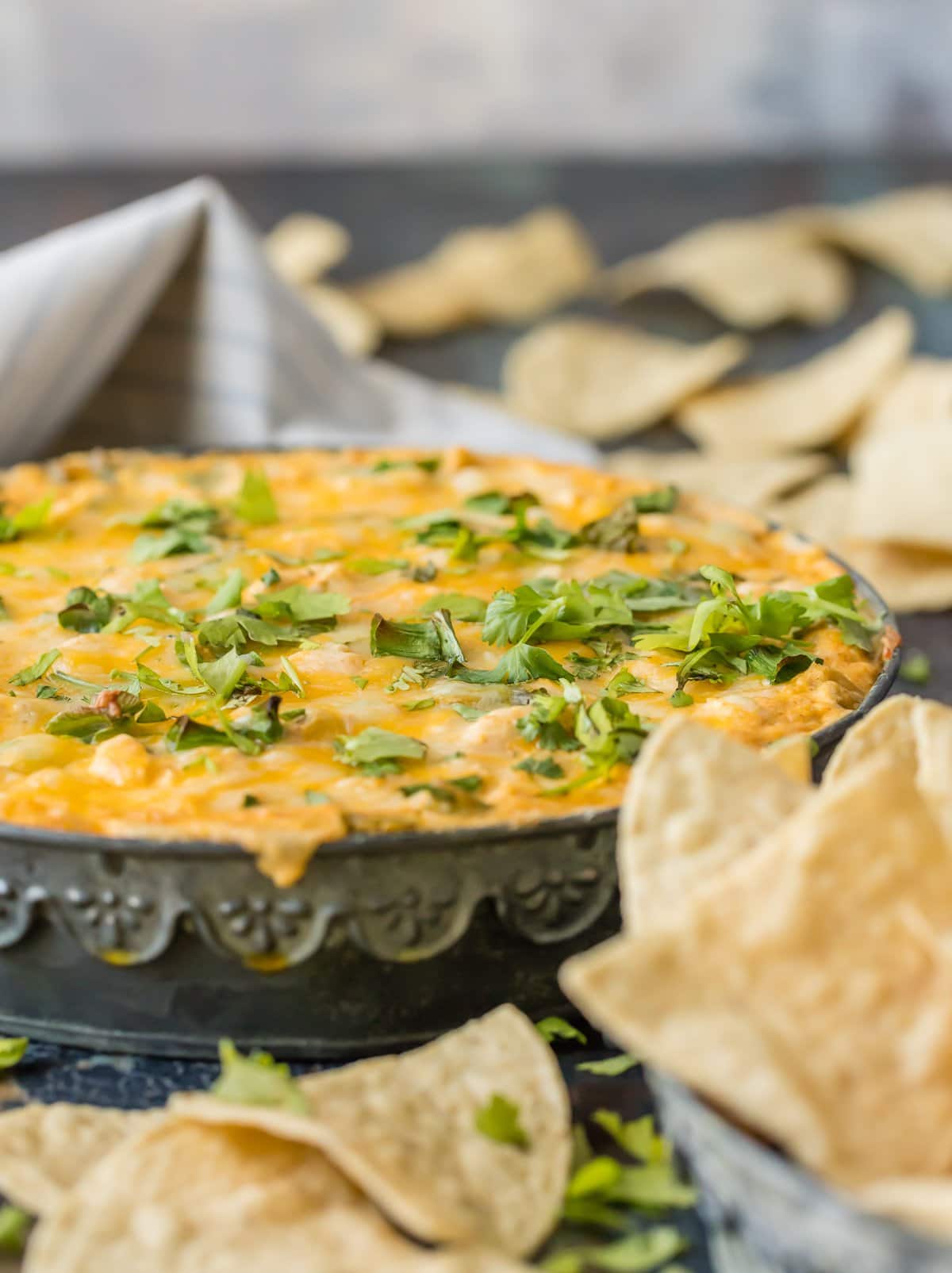 Large bowl of chicken enchilada dip surrounded by tortilla chips