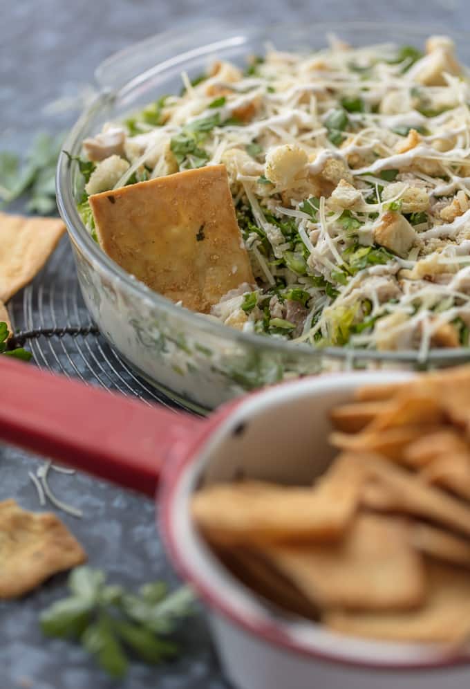 A bowl of creamy chicken caesar dip with pita chips